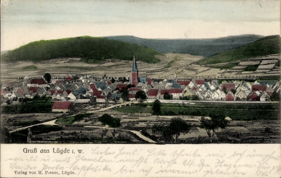 TP Lügde en Weserbergland, paisaje con casas, iglesia, colinas, texto 'Saludos desde Lügde i. W.'